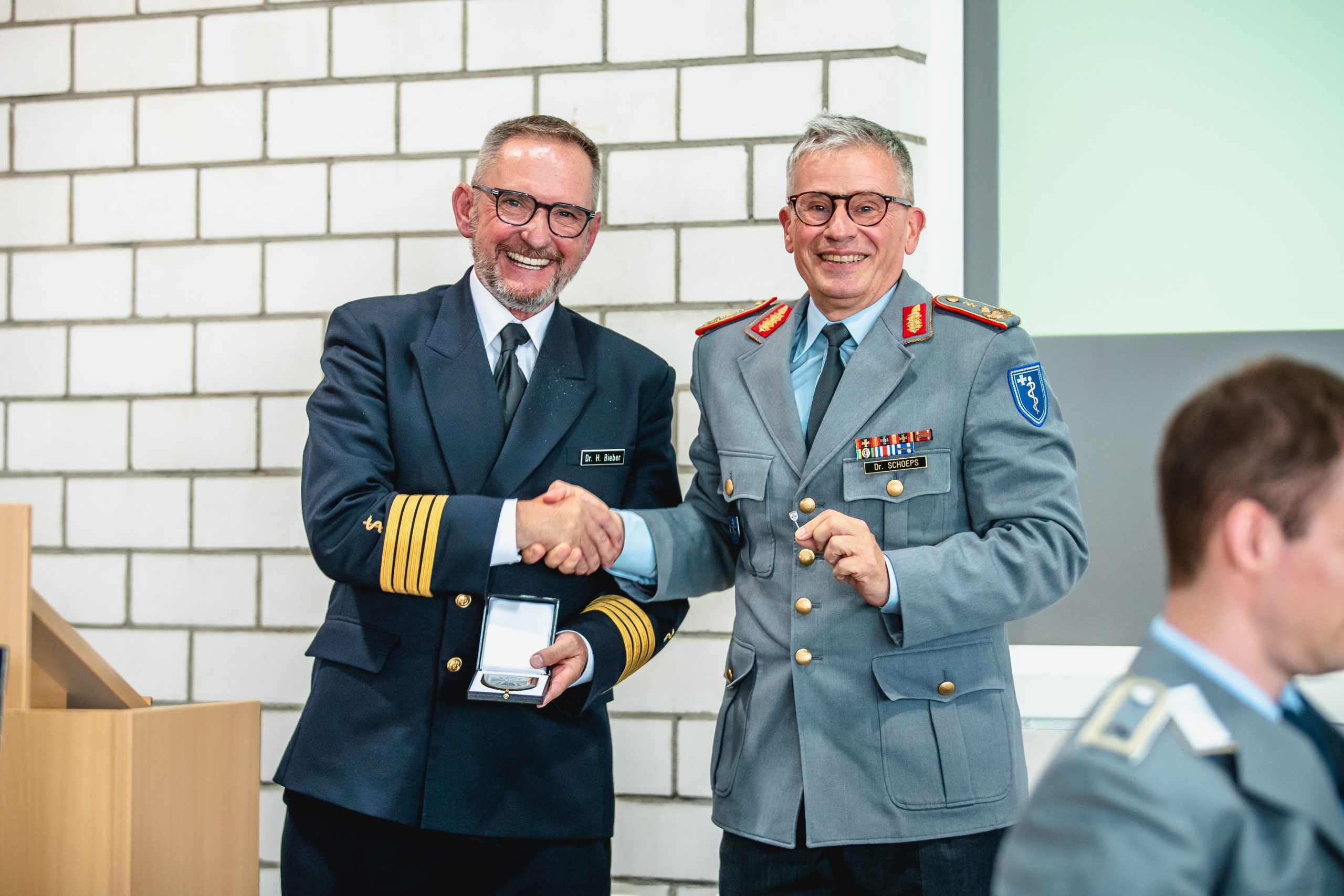 : Generalstabsarzt Dr. Stefan Schoeps überreicht Flottenarzt Dr. Helfried Bieber die Pro Meritis Medaille und Nadel.